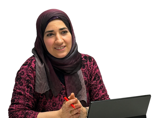 Eine junge Frau mit Hijab vor einem Laptop lächelt